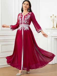 Close-up of elegant burgundy maxi dress with intricate silver floral embroidery and V-neck