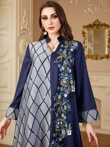 Détail de broderies florales et paillettes sur robe à empiècements contrastés