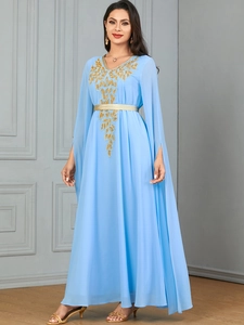 Detail of light blue maxi dress featuring gold embroidery and split long sleeves