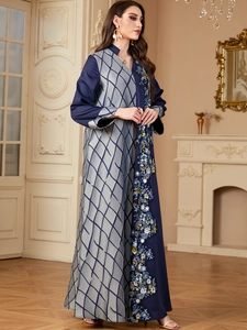 Gros plan sur une abaya élégante avec broderie florale et coutures contrastées