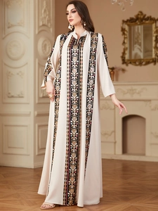Detailed embroidery with colorful floral patterns and sequins on the sleeves of a beige dress