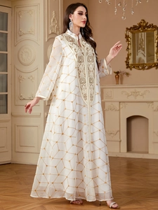 Robe longue blanche en mousseline avec broderies dorées et motifs géométriques