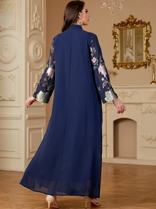 Detail of floral sequin embroidery and tassels on the sleeves of a navy blue maxi dress