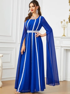 Dettaglio dell'abito da sera in chiffon blu reale con pizzo bianco e maniche lunghe a mantella