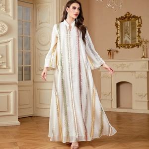 White chiffon kaftan dress with colorful embroidery and long flared sleeves in a room