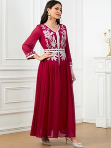 Macro detail of elegant silver floral embroidery on a wine red chiffon evening gown