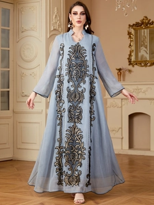 Broderie détaillée sur une robe de soirée bleu clair à manches longues et style rétro