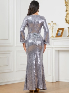 Back view of silver sequin evening gown showing the slim fit fishtail and bow tie waist