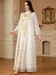 Kaftan blanc élégant avec broderies dorées et motifs géométriques en décor de luxe