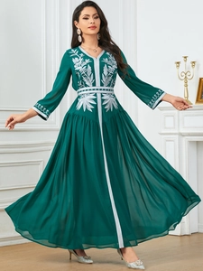 Detail of dark green maxi dress with silver floral embroidery and pleated chiffon skirt