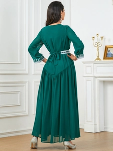 Detail of dark green maxi dress featuring silver waist embroidery and back bow tie design