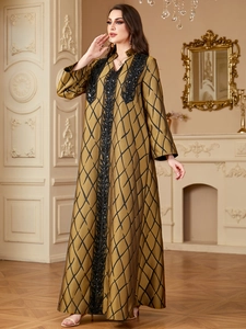 Close-up of black sequin embroidery on bronze maxi dress with geometric patterns