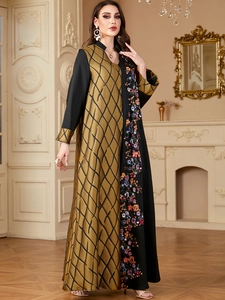 Détail d'une abaya élégante noir et or avec broderies florales et détails à paillettes