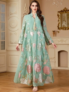 Détail de la robe vert menthe avec broderies florales roses et sequins brillants discrets