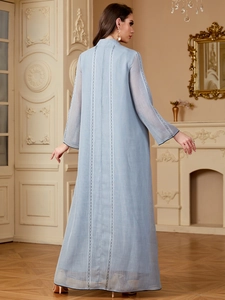 Détail de la robe brodée bleu clair avec dentelle blanche et style de design bohème