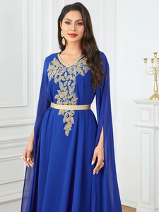 Detail of navy blue caftan featuring gold leaf embroidery and split fringe long sleeves