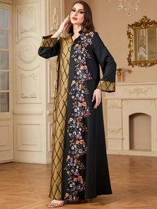 Détail de broderie florale et motif en losange sur la robe caftan noire et dorée