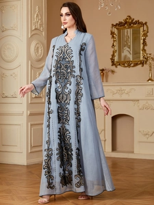 Détails de broderie complexe noire et bronze sur le décolleté d'une robe Abaya bleue