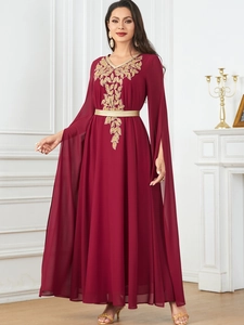 Detail of burgundy maxi dress with gold leaf embroidery and elegant split cape sleeves