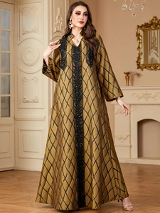 Detail view of luxury bronze gold kaftan with black geometric patterns and sequined embroidery