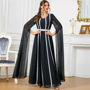 Elegante abito da sera nero con strisce di pizzo bianco e maniche lunghe a mantella