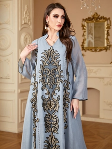 Détail d'un caftan bleu clair avec des broderies baroques complexes en or et en noir