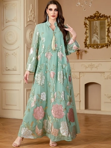 Détail du caftan vert menthe avec broderie florale rose, paillettes et col à glands