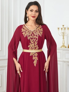 Detail of burgundy chiffon maxi dress featuring gold leaf embroidery and V-neckline