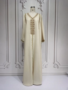 Detail of gold embroidery and red beadwork on cream Turkish kaftan dress