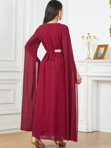 Detail view of the elegant burgundy long dress featuring cape sleeves and a gold belt accent