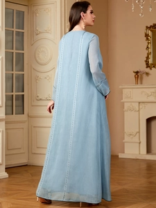 Détail de la robe brodée bleu clair avec dentelle dans le dos et manches longues