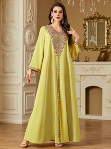 Detail of lime green abaya featuring colorful beadwork and intricate embroidery patterns
