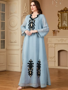 Détail d'un caftan bleu ciel élégant avec broderies symétriques et col en V chic