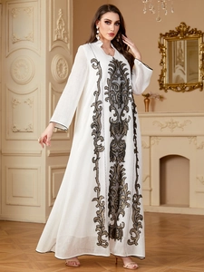 Détails d'une robe Abaya blanche avec broderies dorées et décolleté en V élégant