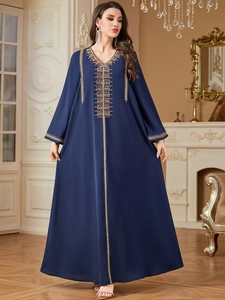 Detail of golden embroidery and beadwork on the V-neck of a navy blue kaftan dress