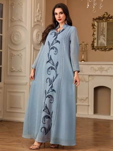 Detailed embroidery on light blue Abaya dress with intricate dark blue vine patterns