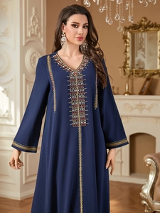 Detailed close-up of dark blue Abaya with intricate beaded embroidery and gold trim
