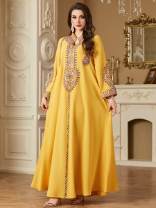 Detail of vibrant yellow Jalabiya with colorful ethnic embroidery and sequins on chest
