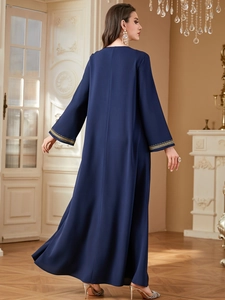 Navy blue kaftan dress featuring gold embroidered cuffs and a flowing silhouette