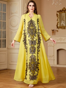 Détail de la broderie noire complexe sur le devant de cette robe caftan jaune vif