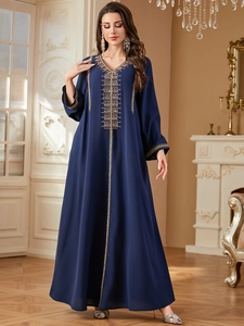 Detail of navy blue kaftan dress with intricate gold and red beaded embroidery craftsmanship