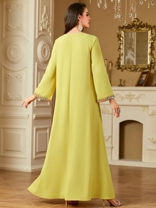 Detailed view of lime yellow abaya with colorful geometric embroidery on the sleeves