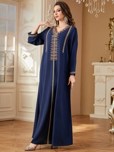 Detailed view of intricate embroidery and beadwork on the neck of a navy blue kaftan dress