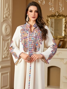 Elegantes weißes langärmliges Kaftan-Kleid mit bunten Paillettenstickereien und Ethno-Mustern