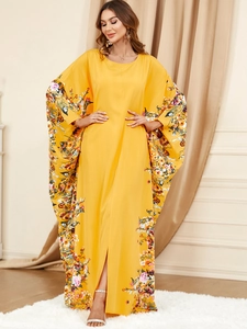 Détail d'une robe caftan jaune avec manches chauve-souris fleuries et coupe fluide élégante