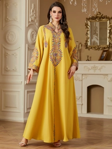 Detailed embroidery on mustard yellow bohemian kaftan with ethnic geometric patterns