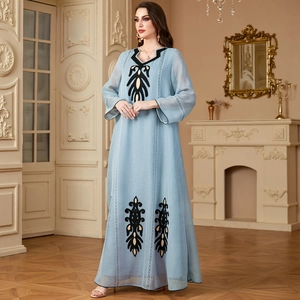Robe longue bleu clair à manches longues et broderies noires en décor classique