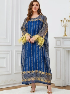 Détail de la broderie à paillettes dorées sur une robe caftan fluide bleu marine