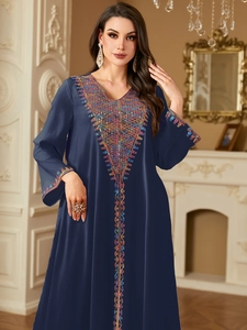 Detail of colorful geometric embroidery on navy blue kaftan dress with V-neckline
