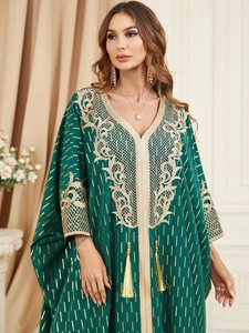 Detail of emerald green kaftan with intricate gold embroidery and tassel neck ties